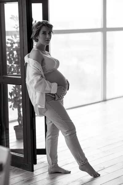 Νεαρή Ευτυχισμένη Έγκυος Γυναίκα Στέκεται Κοντά Στο Παράθυρο Στο Δωμάτιο — Φωτογραφία Αρχείου