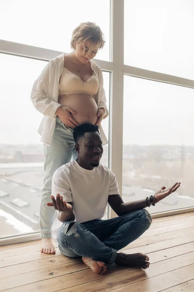 Tânărul African Fericit Meditează Lângă Femeia Însărcinată Caucaziană Fereastră Conceptul — Fotografie, imagine de stoc