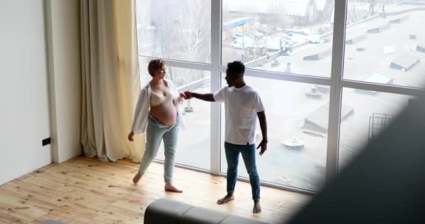 Jovem Homem Africano Feliz Sua Mulher Grávida Caucasiana Divertem Dançam — Vídeo de Stock