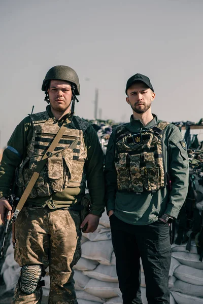ウクライナの領土防衛戦士は 自動銃でボディアーマーのチェックポイントにボランティアの近くに立っています ウクライナにおけるロシアの軍事侵攻の概念 ウクライナとヨーロッパでの戦争 — ストック写真