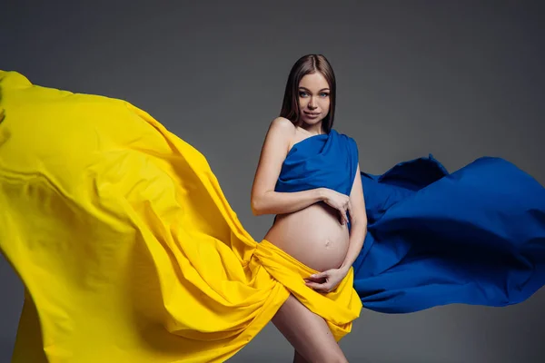 Femme Enceinte Tient Enveloppé Dans Tissu Ressemblant Drapeau Ukrainien Studio — Photo