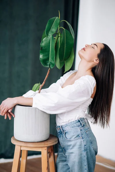 Young Brunette Woman Stands Closed Eyes Relaxes Next Flowerpot Ficus — Stock Photo, Image