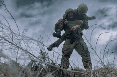 Ukraynalı asker, Rus düşmanına karşı savaştan sonra yaralı savaşçıyı taşıyor. Ukrayna 'da Rus askeri istilası kavramı. Ukrayna ve Avrupa 'da savaş.