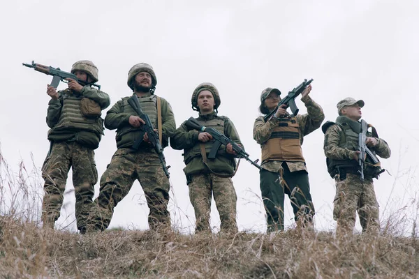 5人のウクライナ兵のチームは空を背景に乾燥した草の間でKalashnikov攻撃ライフルで立っている ウクライナにおけるロシアの軍事侵攻の概念 ウクライナとヨーロッパでの戦争 — ストック写真