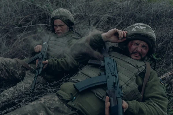 2人のウクライナ兵は ロシアの敵による砲撃の間 乾いた草の上にカラシニコフのアサルトライフルで横たわっている ウクライナにおけるロシアの軍事侵攻の概念 ウクライナとヨーロッパでの戦争 — ストック写真