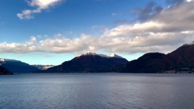 İtalya 'daki Como Gölü' nün panoramik manzarası, pitoresk gökyüzü ve karla kaplı tepeleri olan Alpler..