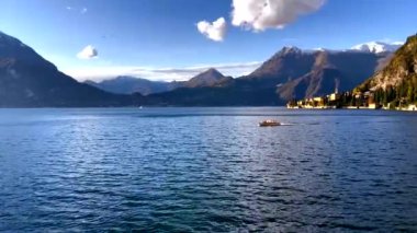 Kasabanın arka planında yüzen tekneyle Como Gölü ve Alp dağlarının zirveleri karla kaplıydı..