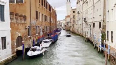 Venice caddesinde dar bir kanal yüzen tekneli evler ve yan taraftaki park edilmiş tekneler arasında..