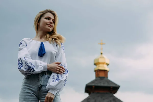 금발의 우크라이나 국기에 수놓은 셔츠를 있습니다 십자가와 하늘을 배경으로 — 스톡 사진