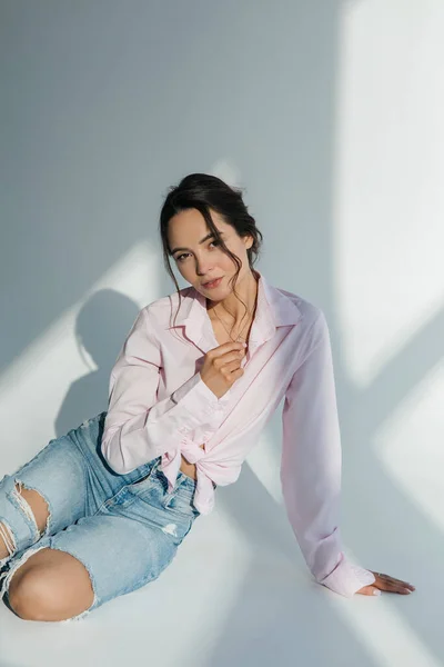 Young Slim Brunette Woman Ripped Jeans Shirt Sits Sunlit — Foto Stock