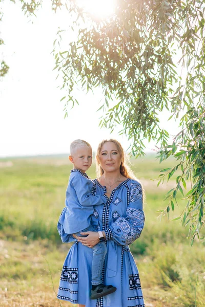 Happy Mother Holds Her Son Hands Walk Meadow Dressed Ukrainian — стоковое фото