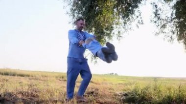 Mutlu baba oğluyla oynar ve parkta yürürken ellerini tutarak döner. Ukrayna ulusal nakışlı gömlekler giyiyorlar..