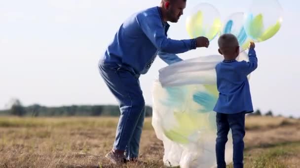 Küçük Oğlu Çayırdaki Çuvaldan Balon Çıkarması Için Babasına Yardım Ediyor — Stok video