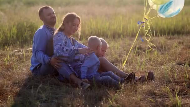 Gelukkige Ouders Met Twee Hun Tweeling Zonen Zitten Gras Rusten — Stockvideo