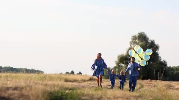 Ikiz Oğlu Olan Mutlu Ebeveynler Hava Balonlarıyla Çayırlarda Koşup Eğleniyorlar — Stok video