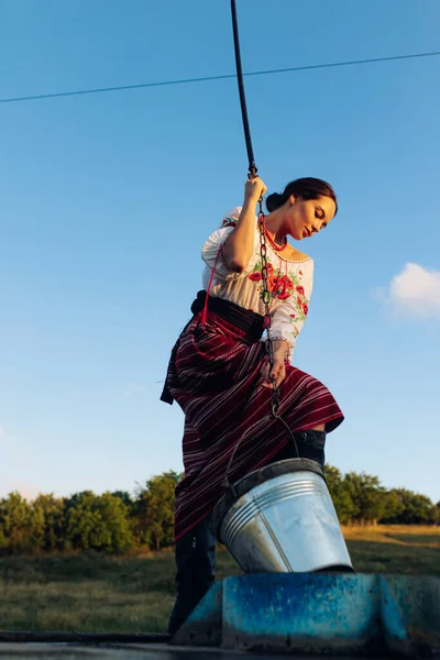 Молодая Украинка Стоит Традиционной Национальной Вышитой Рубашке Юбке Черпает Воду — стоковое фото