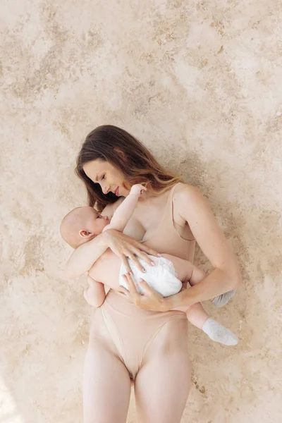 Νεαρή Χαμογελαστή Μητέρα Κοστούμι Στέκεται Και Αγκαλιάζει Μωρό Της — Φωτογραφία Αρχείου