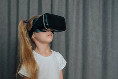 Evde sanal gerçeklik gözlüklü çocuk video izleyip oyun oynuyor. Modern çocuklar teknolojik yenilikler konusunda çok bilgilidirler. Alfa kuşağı. Yüksek kalite fotoğraf