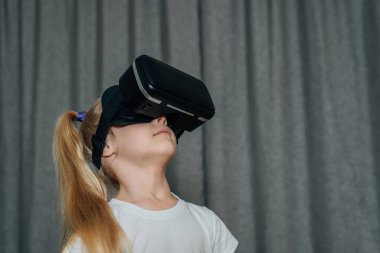Evde sanal gerçeklik gözlüklü çocuk video izleyip oyun oynuyor. Modern çocuklar teknolojik yenilikler konusunda çok bilgilidirler. Alfa kuşağı. Yüksek kalite fotoğraf
