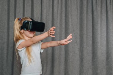 Evde sanal gerçeklik gözlüklü çocuk video izleyip oyun oynuyor. Modern çocuklar teknolojik yenilikler konusunda çok bilgilidirler. Alfa kuşağı. Yüksek kalite fotoğraf