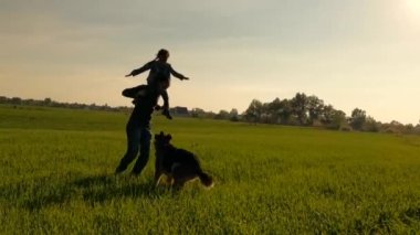 Köpeği gezdiren mutlu bir aile. Küçük kız babasının omzunda oturuyor.