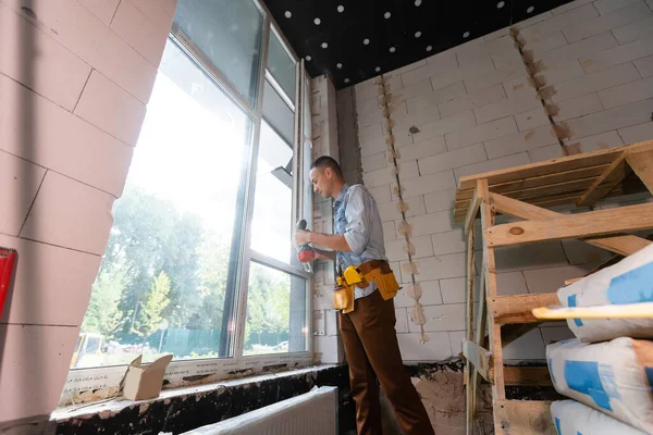 Stavební dělník instaluje okno v domě — Stock fotografie