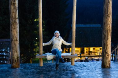 Beyaz kadın salıncakta oturuyor. Yeni yıl ilhamı ve kış tatili kavramı.