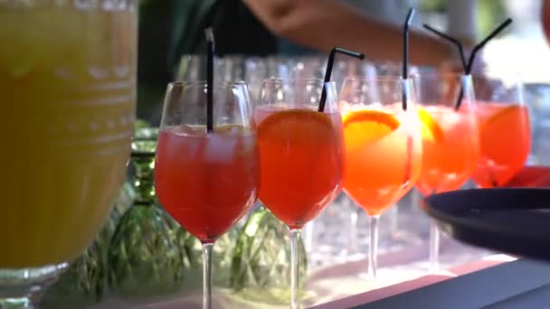 Cubo de gelo caindo em um copo de coquetel laranja. Aperol spritz — Vídeo de Stock