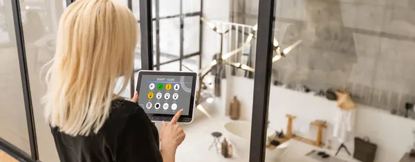 Γυναικεία χέρια κατέχουν ένα tablet υπολογιστή με σύστημα έξυπνο σπίτι σε μια οθόνη — Φωτογραφία Αρχείου