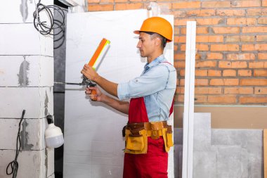 Onarım, bina, inşaat, insanlar ve bakım konsepti - duvarın arkasında kaskı olan gülümseyen adam