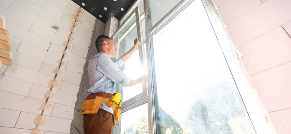 Építési munkások ablakot szerelnek be a házba — Stock Fotó