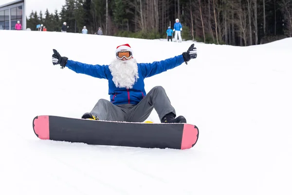 Boldog ember télapó piros karácsonyi kalap snowboard téli hegyek dombon — Stock Fotó