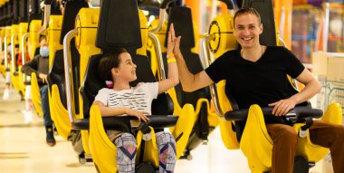 Baba ve kızı lunapark treninde eğleniyorlar.