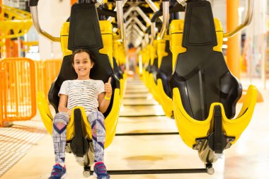 Bir lunaparkta heyecan dolu bir lunaparkta kolları havada ve heyecanla bağıran bir kız.