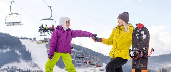 Mutter und Tochter mit Snowboards im Wintersportort — Stockfoto
