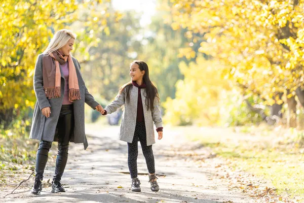 Ung mamma leker med sin dotter i höstparken — Stockfoto