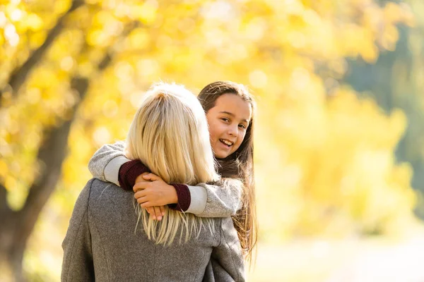 小女孩和她的母亲在秋天的公园里享受阳光明媚的天气 — 图库照片