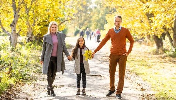 Photo de belle famille dans le parc d'automne, jeunes parents avec un gentil adorable enfant jouant à l'extérieur, amusez-vous sur la cour arrière à l'automne, famille heureuse profiter de la nature automnale — Photo