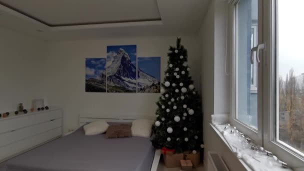 Przytulny pokój z dekoracjami świątecznymi. Boże Narodzenie urządzone sypialnia z wielu świateł i choinki. Choinka z girlandami. — Wideo stockowe