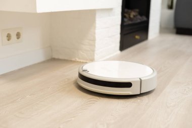 Yerde robotik süpürge var.