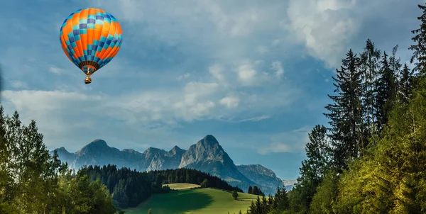 Zonsondergang boven bosberg met heteluchtballon — Stockfoto