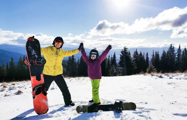 Πορτρέτο της ευτυχισμένης οικογένειας με snowboards κοιτάζοντας κάμερα σε μπλε φόντο — Φωτογραφία Αρχείου