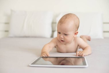 Mutlu bebek yatakta yatarken dijital Tablet vasıl arıyorsunuz