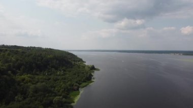 Nehir tarlada, yeşil çimen vadisi nehir kıyısı anteninde. Bahar güneşinde hiç kimse doğa manzarası yaratmaz. Doğal güzellik. Kırsal yeşillik alanları. Sahildeki tarım arazisi