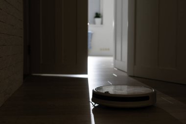 Robot elektrik süpürgesi odayı temizliyor, kimse yok.