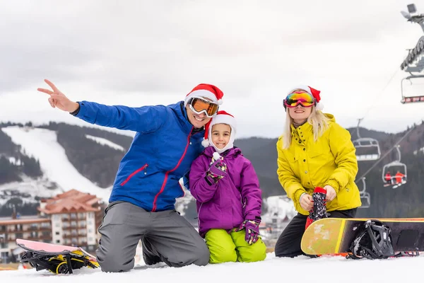 Família em santa chapéus e snowboards — Fotografia de Stock