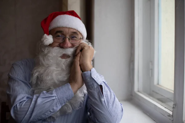 Портрет старшого чоловіка в капелюсі Санта дивиться на камеру — стокове фото
