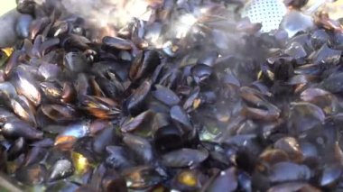 Kaynamış midyeler, koyu ahşap arka planda, bakır yemek kabında yakın plan.