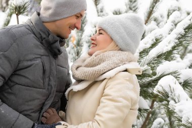 Karlı çamların arasında, kış ormanlarında birbirini seven bir çift.