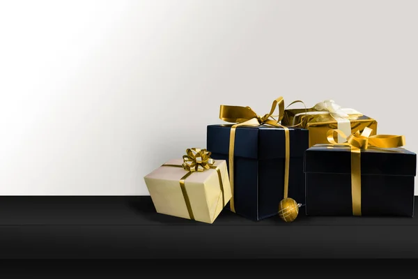 Černé dárky se zlatými stuhami. Vánoční dárkové krabice na černém pozadí. Veselé Vánoce a Veselé svátky blahopřání, rámeček, banner. černý pátek — Stock fotografie